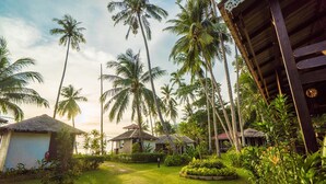 A tropical resort with palm trees, thatched-roof huts, and a well-maintained garden. - 1511 Coconut Grove (Tioman Island)