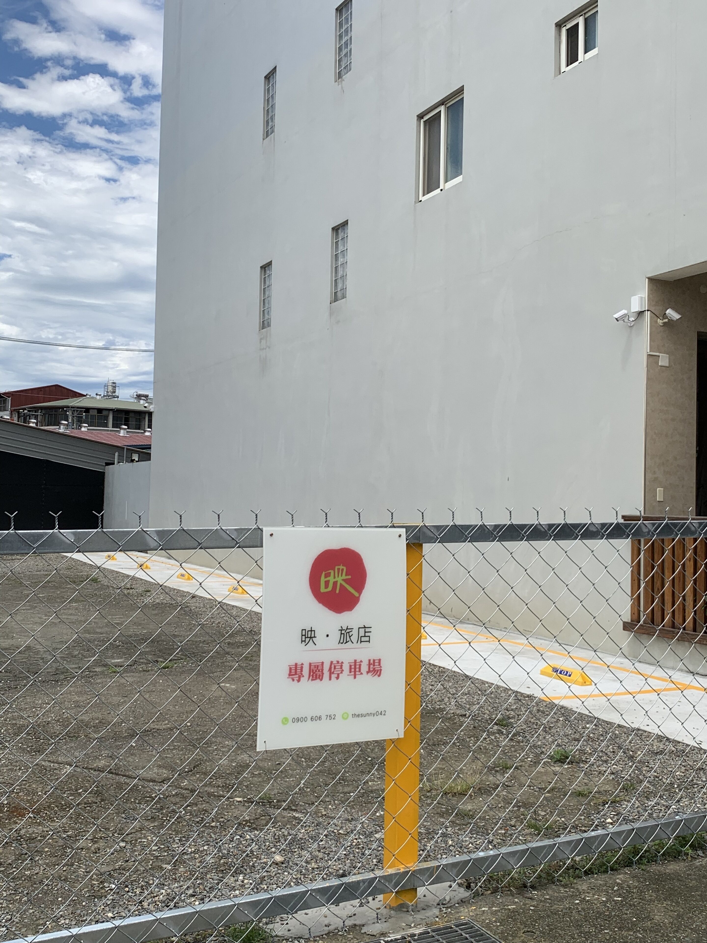 A chain-link fence with a sign indicating a parking area for a hotel.