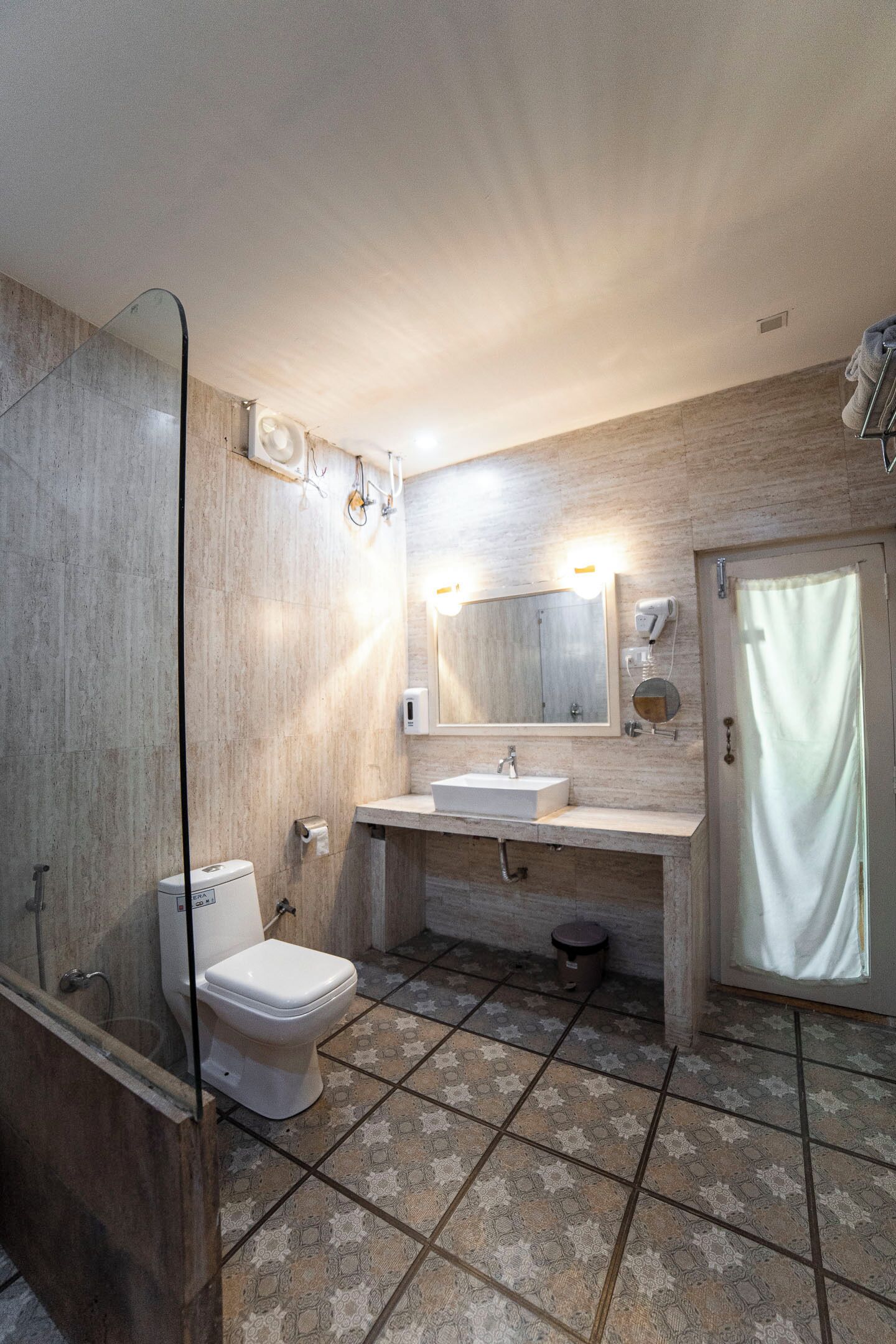 A bathroom with a toilet, sink, and shower area.