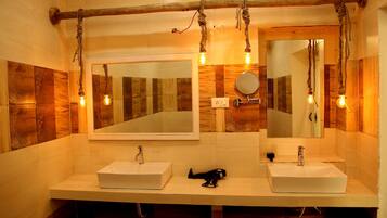 A bathroom with two sinks, wooden wall panels, and light fixtures.
