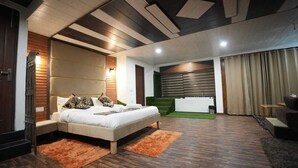 A modern bedroom with a large bed, a green wall, and a separate bathroom area. - Hotel Robinsson Palace (Kosiyakutoli)