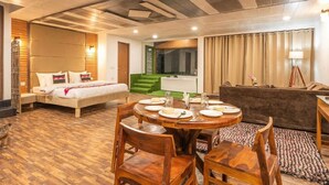 A hotel room with a bed, a sofa, a dining area with a table set for two, and a green accent wall. - Hotel Robinsson Palace (Kosiyakutoli)