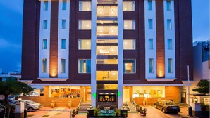 A multi-story hotel with a central atrium, balconies, and a ground-level restaurant. - Hotel Kapish Smart (Jaipur)