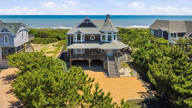 Una casa vista mare con un'ampia terrazza e un garage.