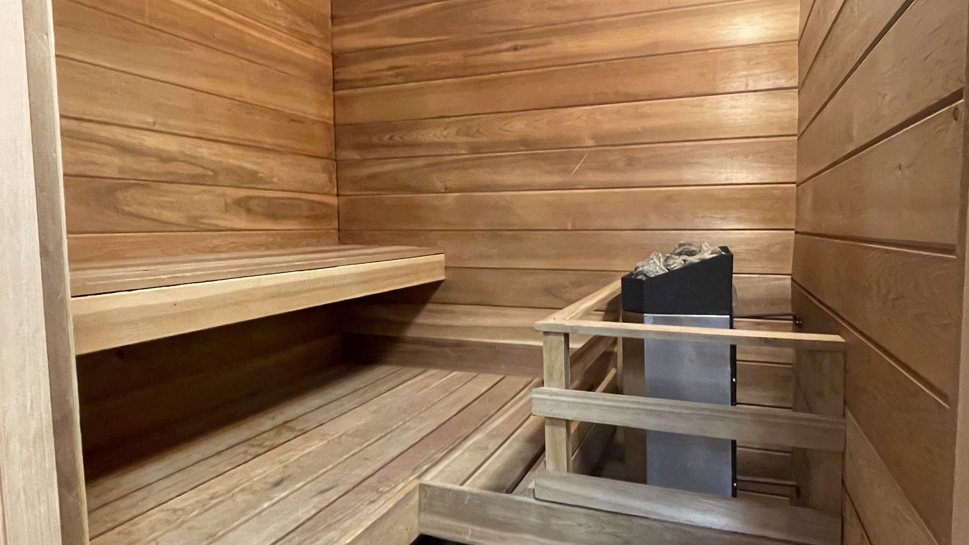 Un sauna avec des murs et des bancs en bois.
