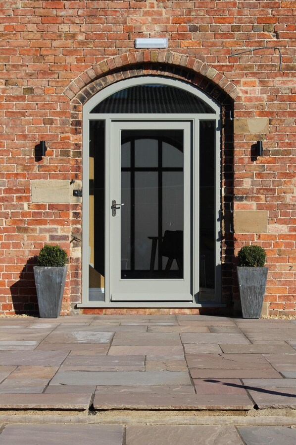 Stunning entrance with a beautifully framed door and lush greenery.