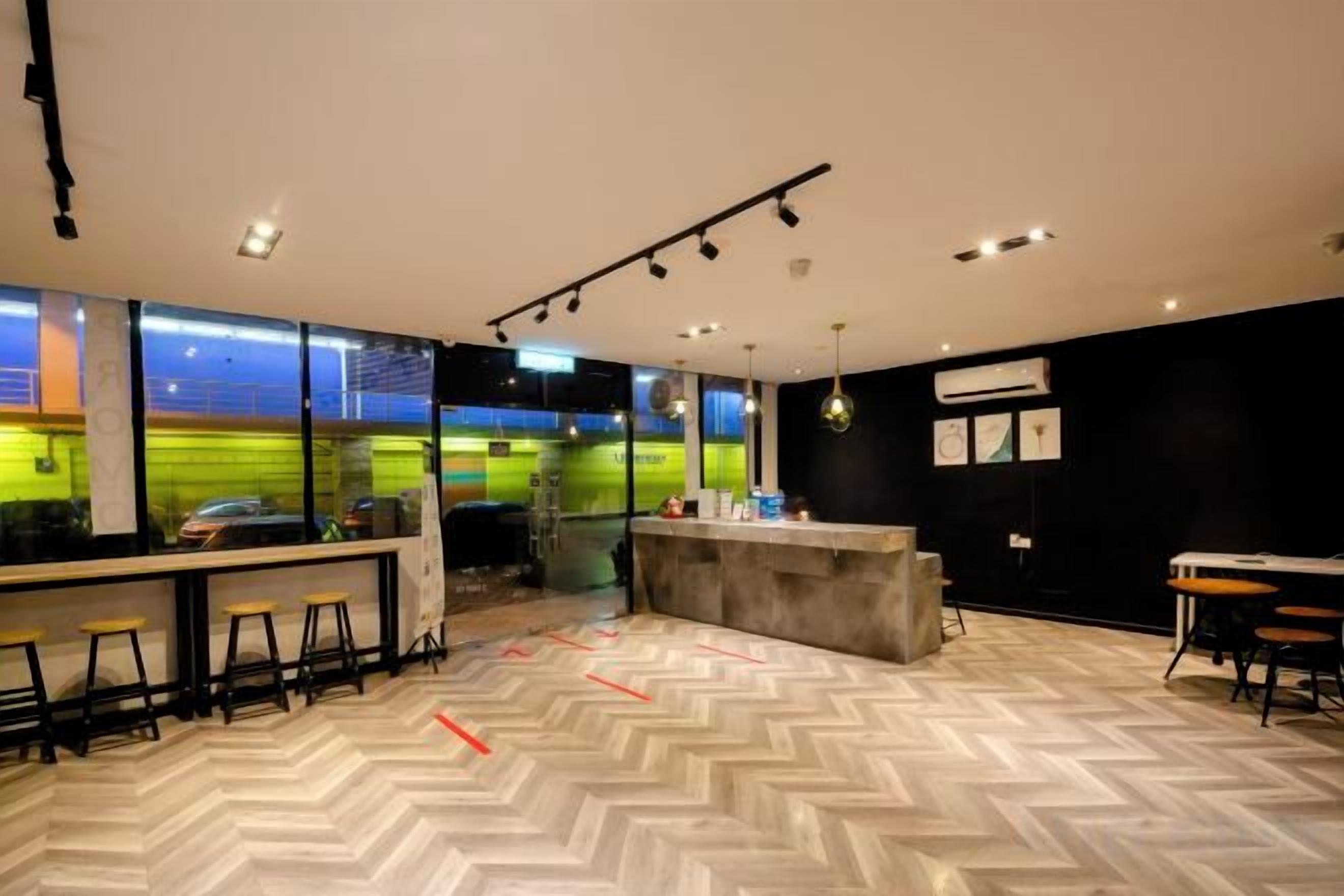 A modern interior with a bar area, seating, and a herringbone floor pattern.
