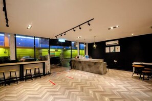 Um interior moderno com área de bar, assentos e padrão de piso em espinha de peixe.