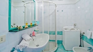 Une salle de bain avec une baignoire blanche, un espace douche, des toilettes et un lavabo.