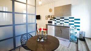A modern kitchen with a microwave, oven, and cabinets. There is a dining table with candles and flowers.
