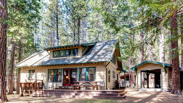 A lodge with a large deck, outdoor seating, and a covered porch.