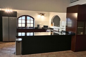 Una cocina con una isla central, un refrigerador y un microondas.