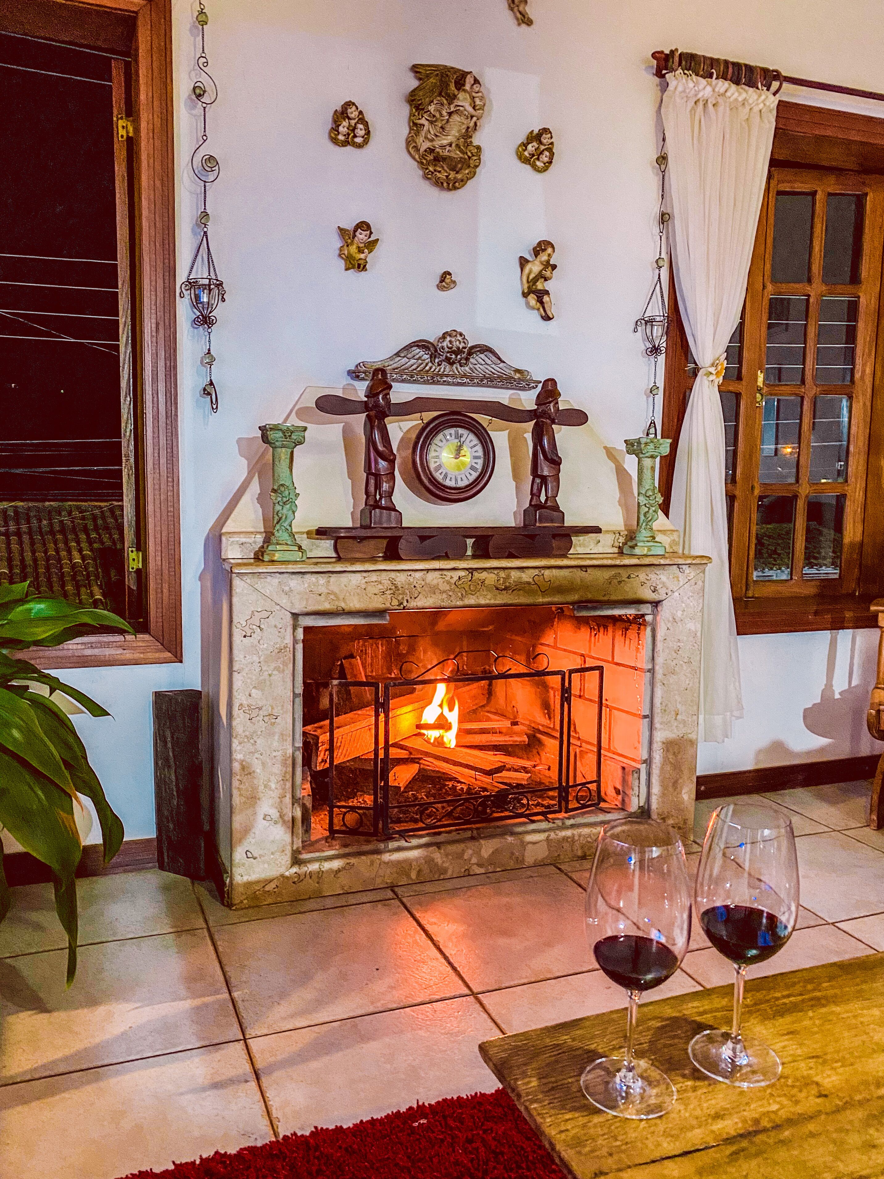 A cozy living room with a fireplace, decorative wall art, and two wine glasses on a table.