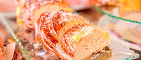 A loaf of bread with a shiny glaze on a glass plate.