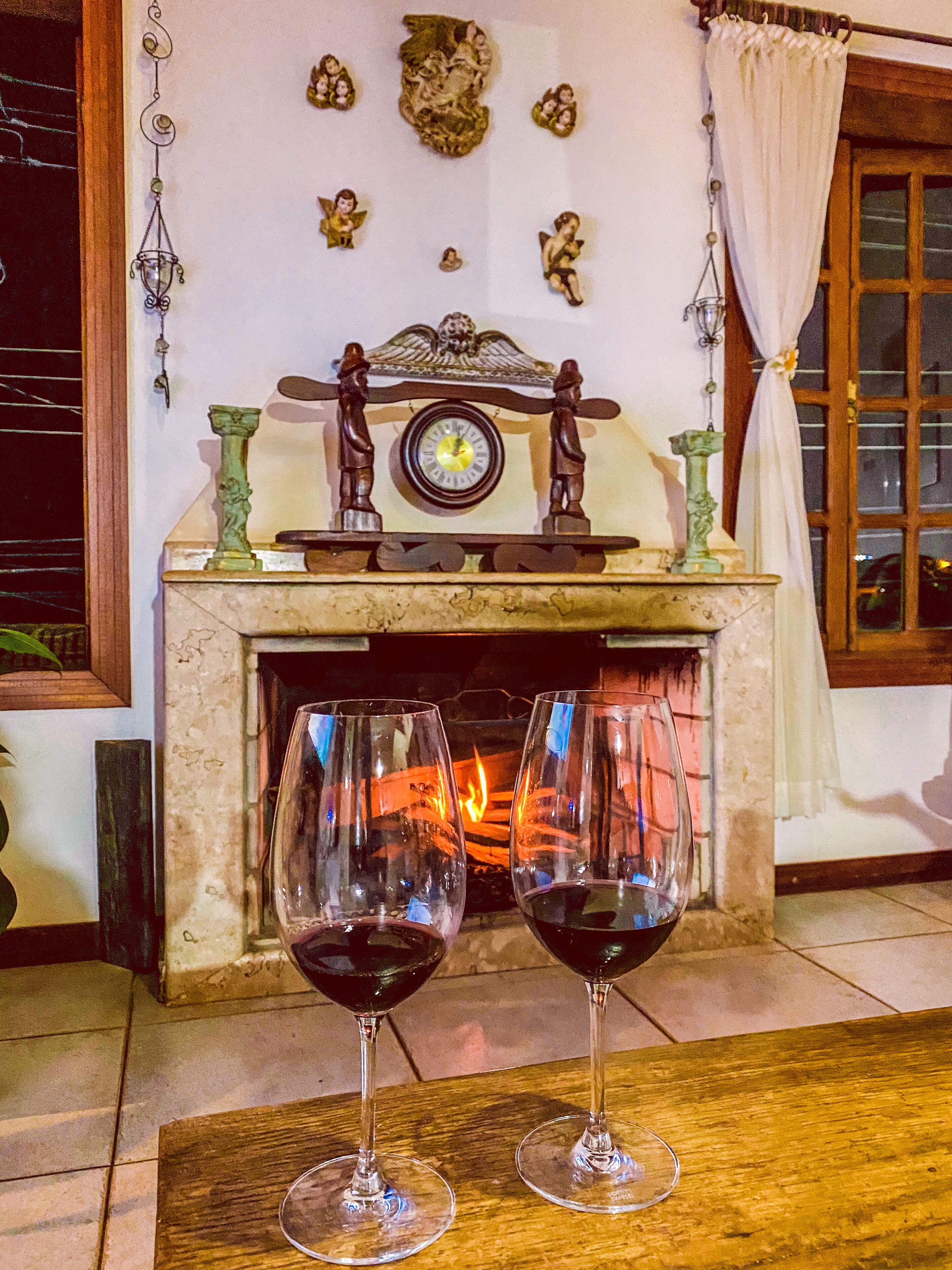 A fireplace with two wine glasses in front.