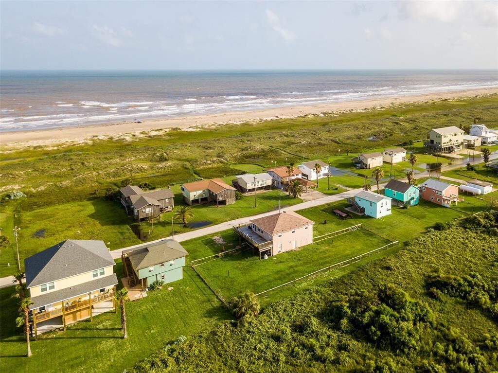 Een woongebied aan de kust, met huizen en een strand op de achtergrond.
