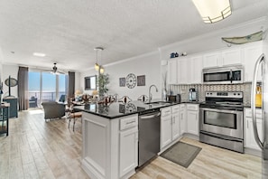 Una cocina moderna con muebles blancos, electrodomésticos de acero inoxidable y una isla grande.