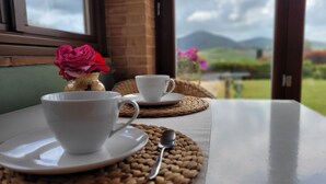 Une table avec une tasse et une soucoupe, une cuillère et un vase rempli de fleurs.