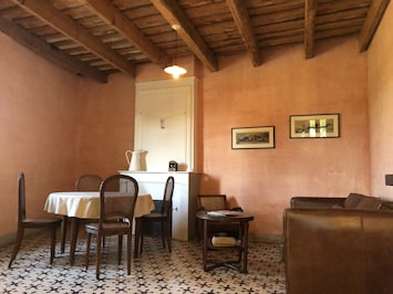 Living/dining room with provencal ceilings, original tiles, and fireplace.