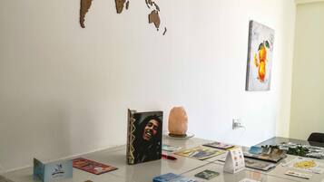 Un escritorio con un mapa del mundo, un cuadro enmarcado y varias revistas.