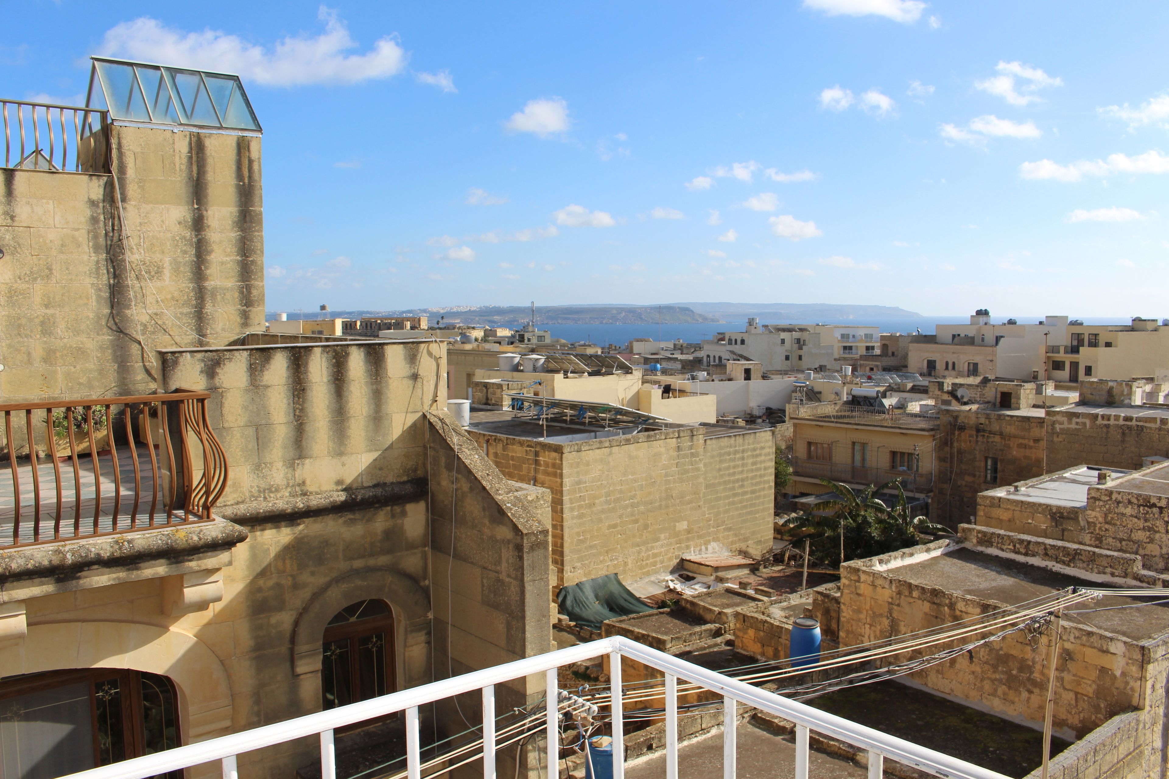 Vista de un paisaje urbano con edificios y un mar lejano.