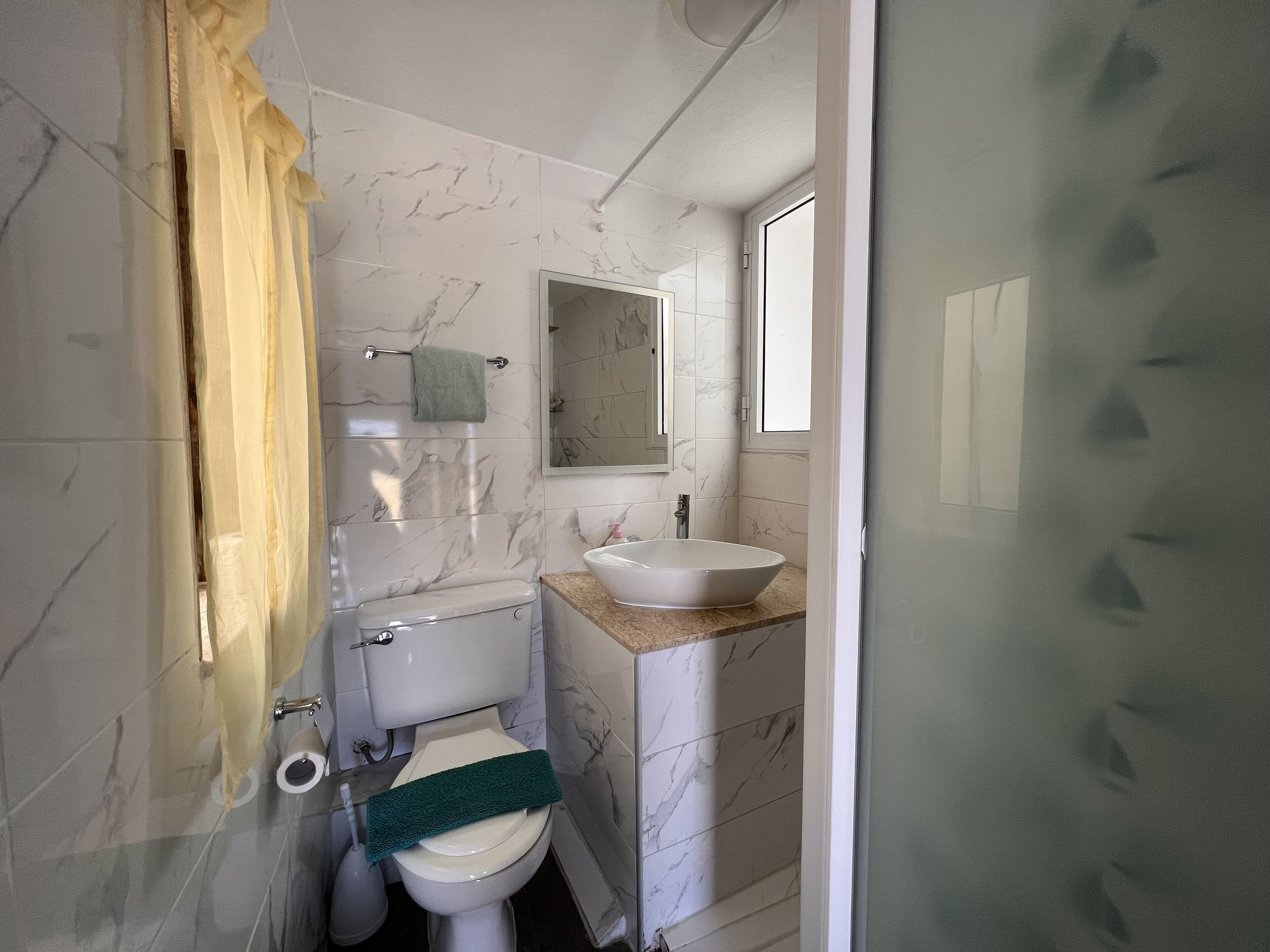 Un bagno con il water, un lavandino e uno specchio.