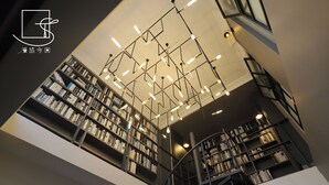 Une bibliothèque à plusieurs niveaux, dotée d’étagères, d’un escalier en colimaçon et d’un éclairage moderne.