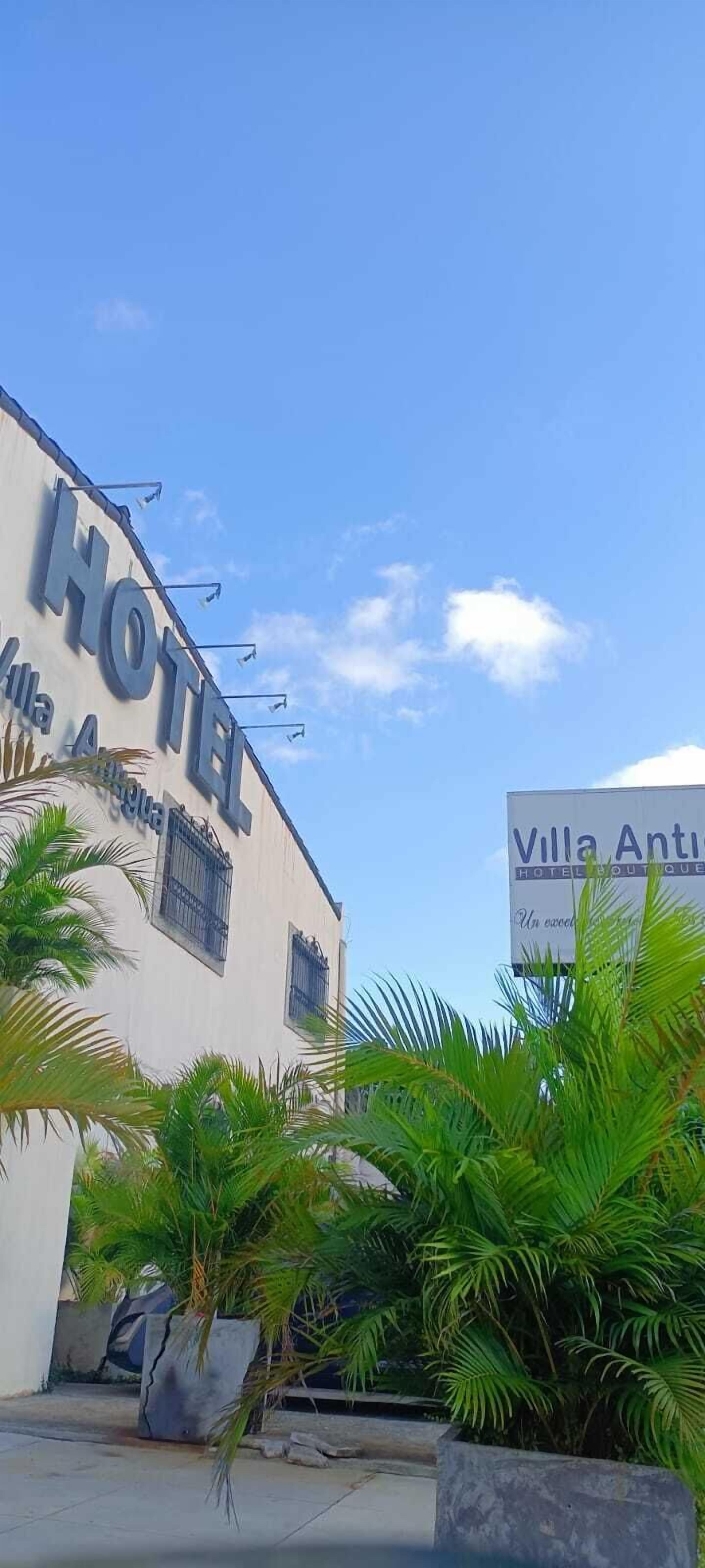 Un hotel con un cartello che riporta la scritta 'Villa Antica HOTEL' e un cielo azzurro limpido.