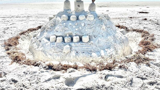 A large sandcastle with multiple tiers and a circular base on a sandy beach. - 4Bdm Waterfront Home w/ Heated Pool, Walk to Beach (Indian Rocks Beach)