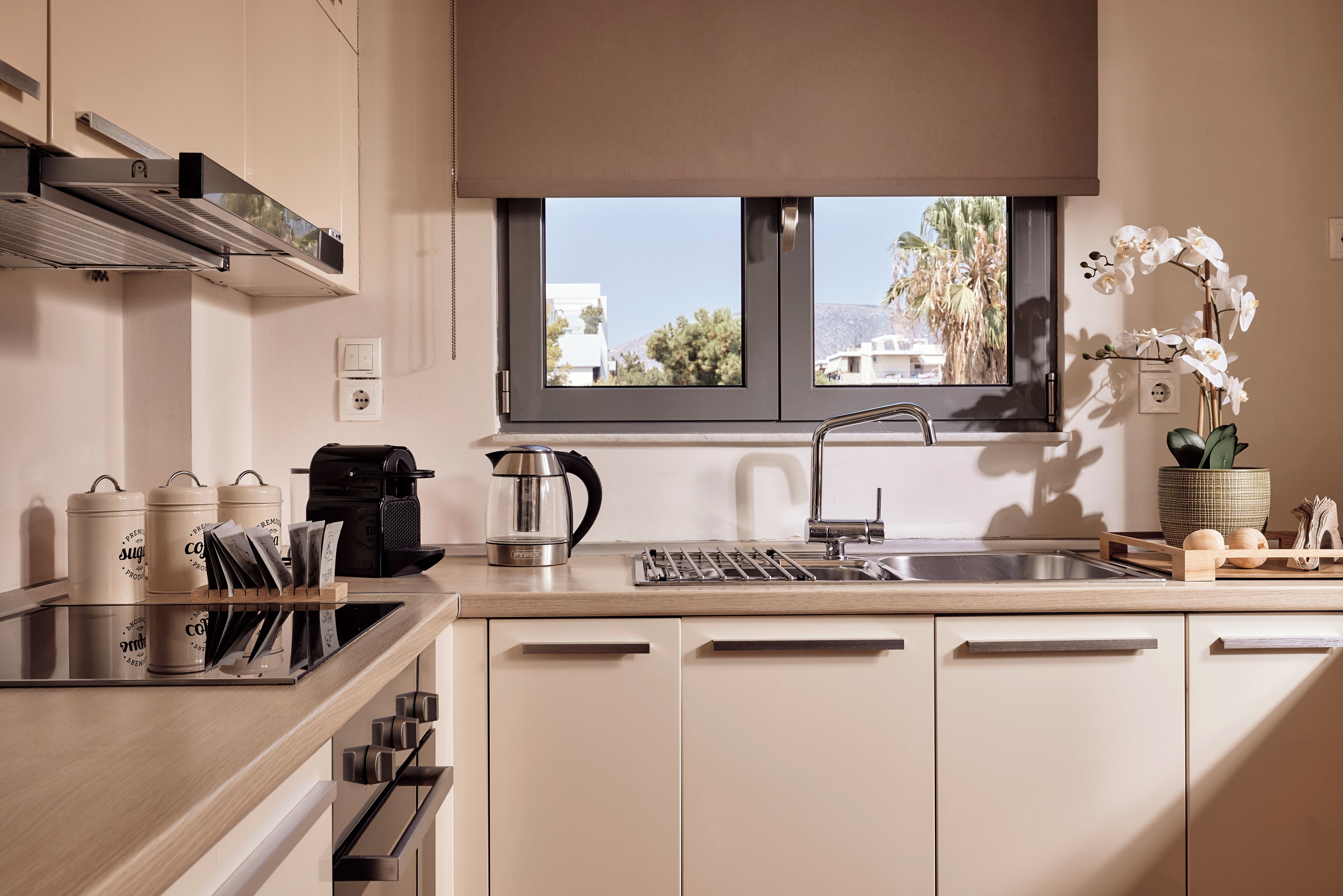 A modern kitchen with a window, a coffee maker, and a sink.