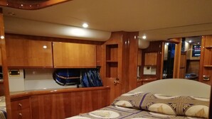 Ein Schlafzimmer mit einem großen Bett, Holzschränken und einer kleinen Sitzecke.