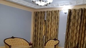 Um quarto com dois sofás, uma mesa de centro e um tapete estampado.