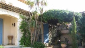 A courtyard with steps leading to a door, surrounded by greenery and a pergola. - VILLA GOLFE DE SAINT TROPEZ (Cogolin)