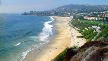 Vlak bij het strand, ligstoelen aan het strand, parasols, strandlakens