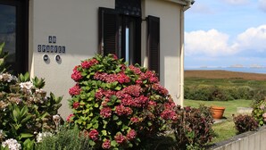 Une maison avec une enseigne indiquant « AR SPARFEL » et une vue sur la mer.