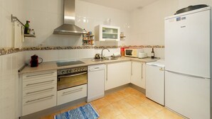 A kitchen with white cabinets, a stove, oven, microwave, and a refrigerator. - Nice apartment in Cabo de Gata (Cabo De Gata)