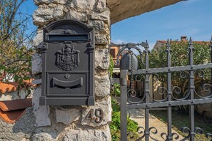 A mailbox with a coat of arms and the number 49 on a stone wall.