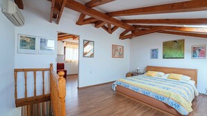 Ein Schlafzimmer mit einem hölzernen Bett, einer Holztreppe und einem großen Fenster.