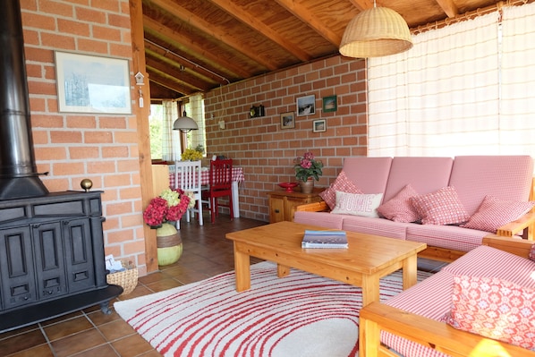 Una sala de estar acogedora con pared de ladrillo, un conjunto de sofás, una mesa de centro de madera y una chimenea.