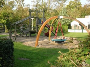 Un parque infantil con columpios y estructuras para escalar.