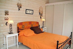 A bedroom with a bed, two bedside tables, and wall decorations.