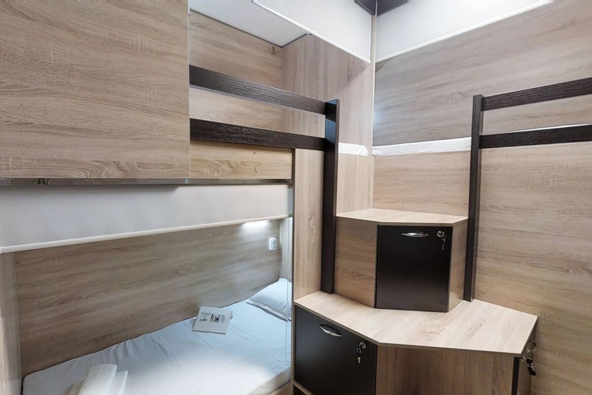 Una cama litera con un escritorio y un mueble pequeño.