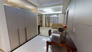Una sala de estar moderna con comedor, que incluye un sofá, una mesa de centro y un jarrón con flores.