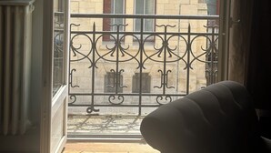 A view from a balcony with a wrought iron railing, looking out at a building with multiple windows and a stone facade. - STANDING APARTMENT IN THE CENTER OF LA ROCHELLE 2 STEPS FROM THE OLD PORT AND BEACH (La Rochelle)