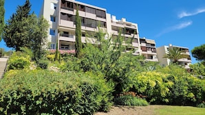 A multi-story residential building with balconies, surrounded by lush greenery and trees. - Cassis 62m2 + Balcony 10m2, Air Conditioning, Panoramic Sea View, Pool, Tennis (Cassis)