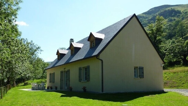 A single-story house with a sloped roof, a front porch, and a small garden area.
