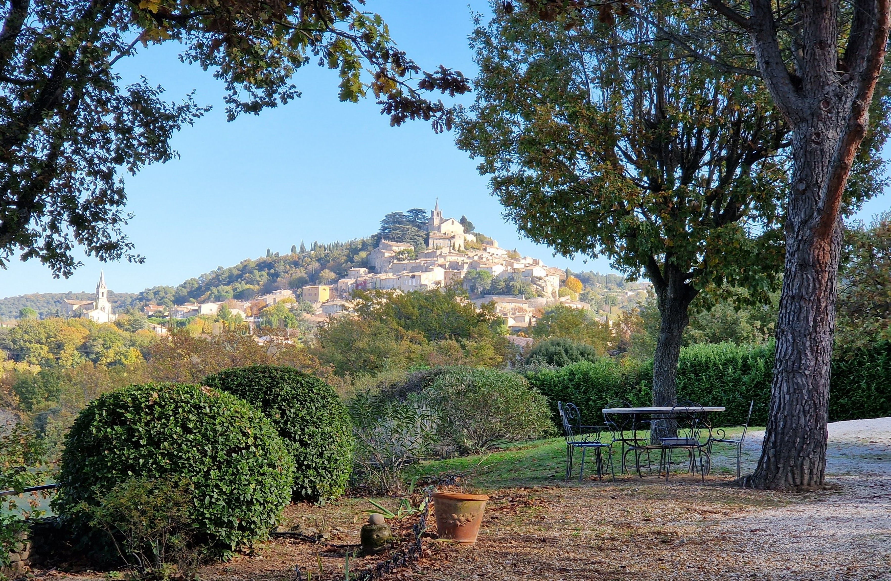 A park with a hilltop view of a historic town, including a church and residential buildings.