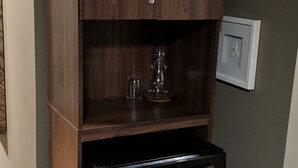 A compact kitchen with a built-in refrigerator and a wooden cabinet above it.