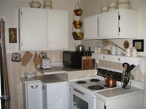 Fully equipped kitchen with a refrigerator, stove, microwave, and various appliances.