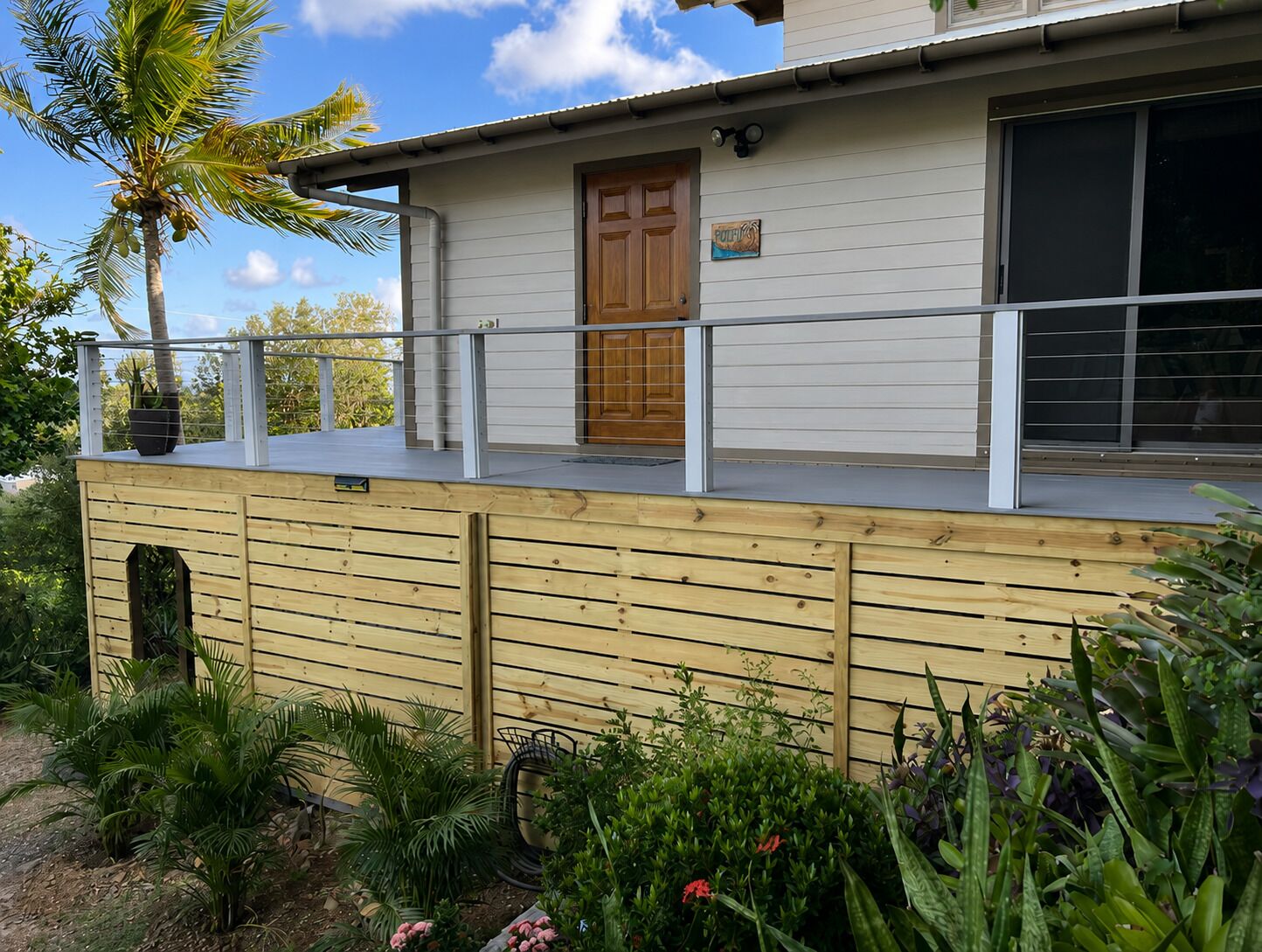 Une maison avec une terrasse en bois, une porte et une fenêtre.
